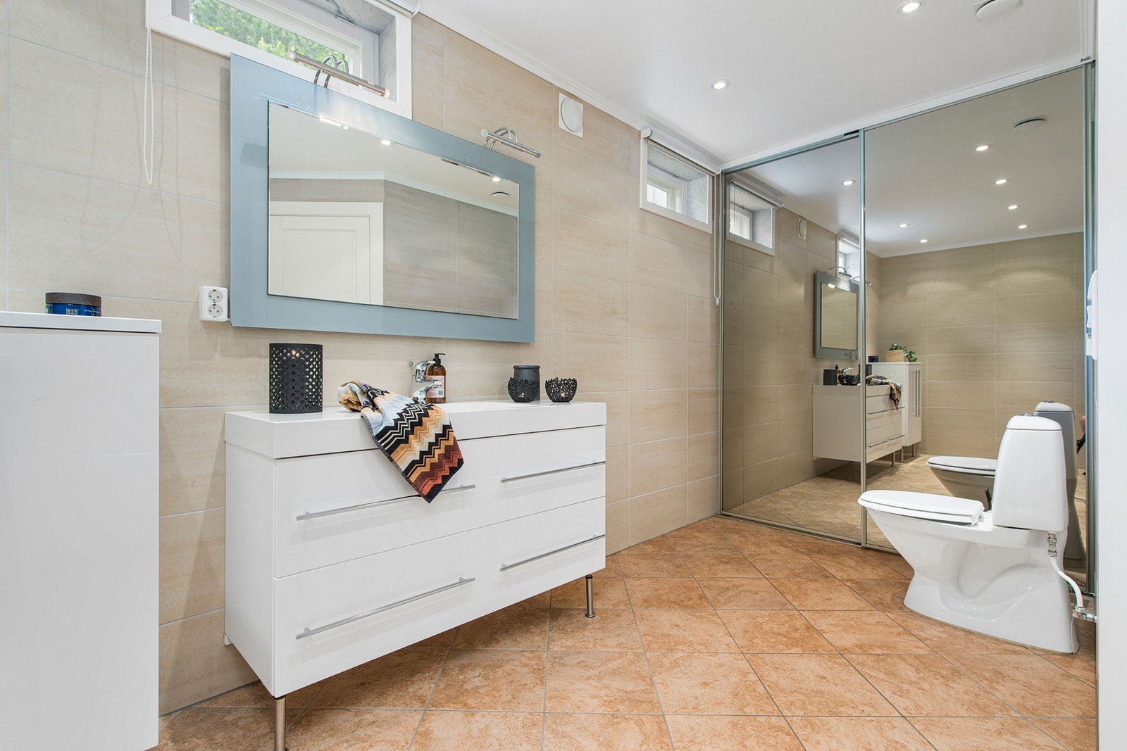 Bad i sokkel på 11,5 kvm.
Bak skyvedørene på badet er opplegg for vaskemaskin samt utslagsvask. Galleribilde