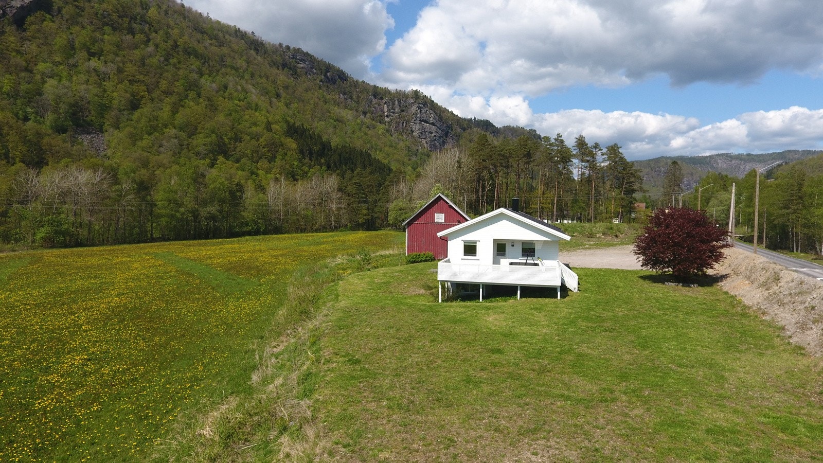 Flat tomt med stor p-plass og plen, samt veranda mot sørvest. Galleribilde