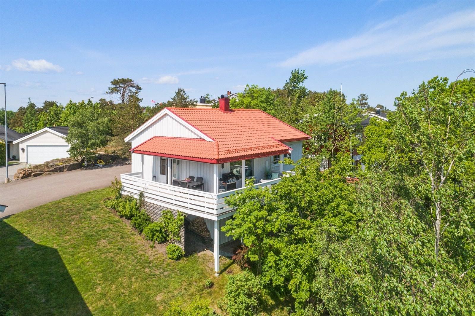 Tomten består av asfaltert adkomst og gårdsplass, naturtomt og noe gressplen. Galleribilde