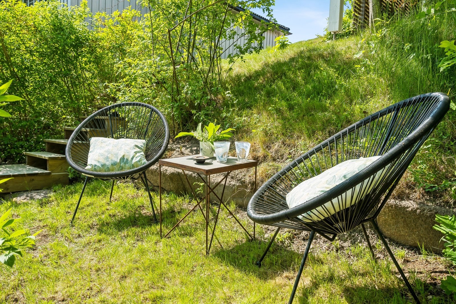 Det er laget til flere hyggelige uteplasser på tomten, her i "skråningen" hvor du sitter helt usjenert i terrenget. Galleribilde