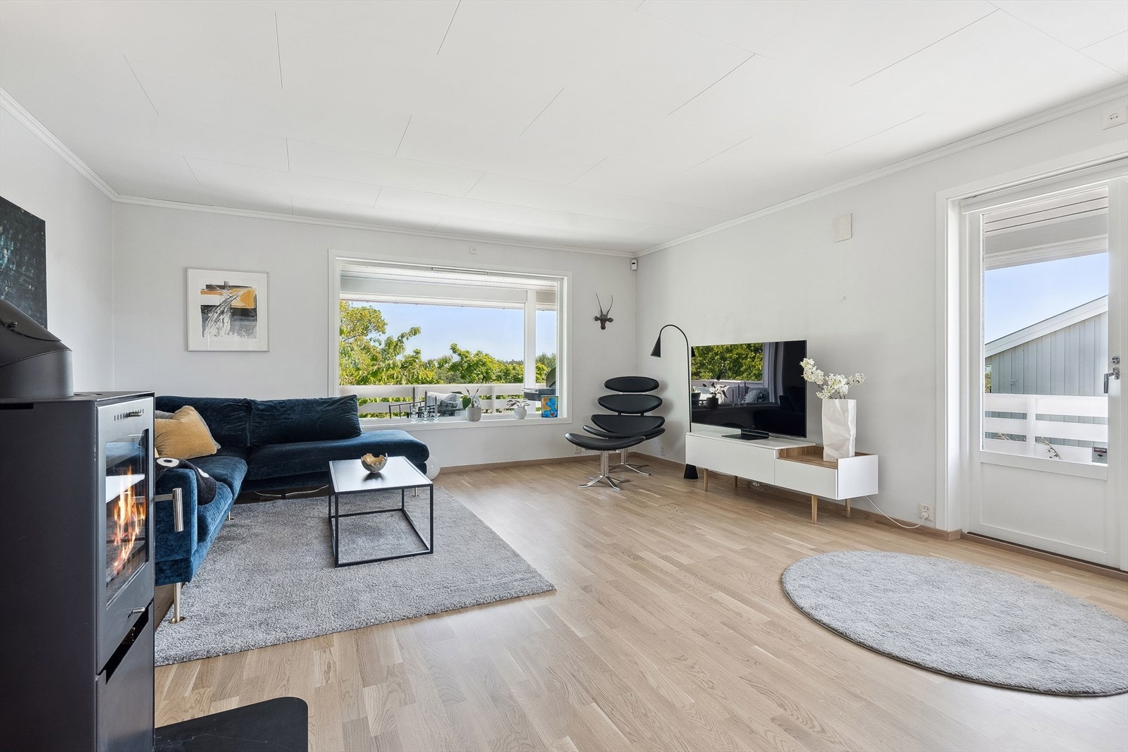 Stuen oppleves svært lys og hyggelig og slipper godt med daglys inn i rommet fra vinduer/dører på tre sider. Galleribilde