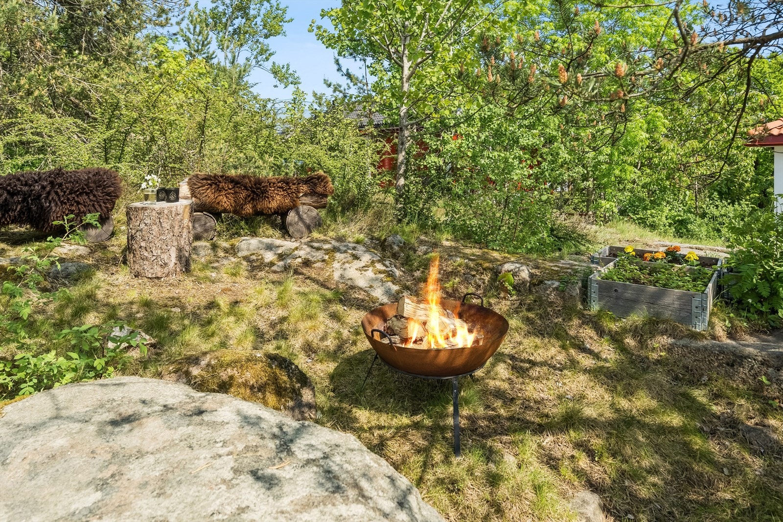 På oversiden av huset er det laget bålplass med sittebenker og bålpanne, samt plantekasser. Galleribilde