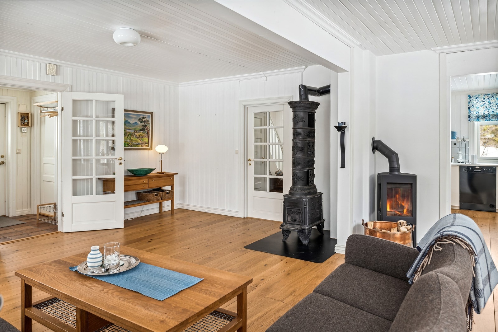 På innsiden av boligen kommer du først til en liten flislagt entré, før du gjennom en glassdør kommer til stuen. I stuen er det plassert en etasjeovn og en peisovn. Galleribilde