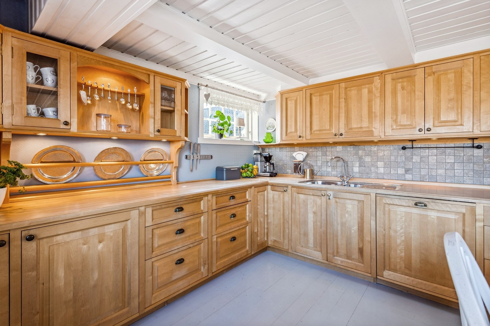 Plassbygd innredning i bjørk og med benkeplate i tre. Montert i en L-form som både gir god plassutnyttelse og samtidig godt med skap- og benkeplass. Galleribilde