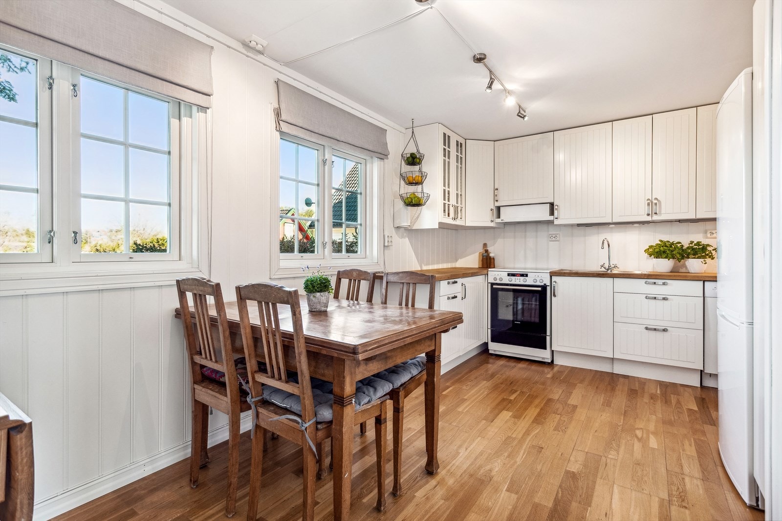 Rommet innredet som kjøkken har hvit, takhøy innredning med plass for komfyr og oppvaskmaskin. Benkeplate i tre. Galleribilde