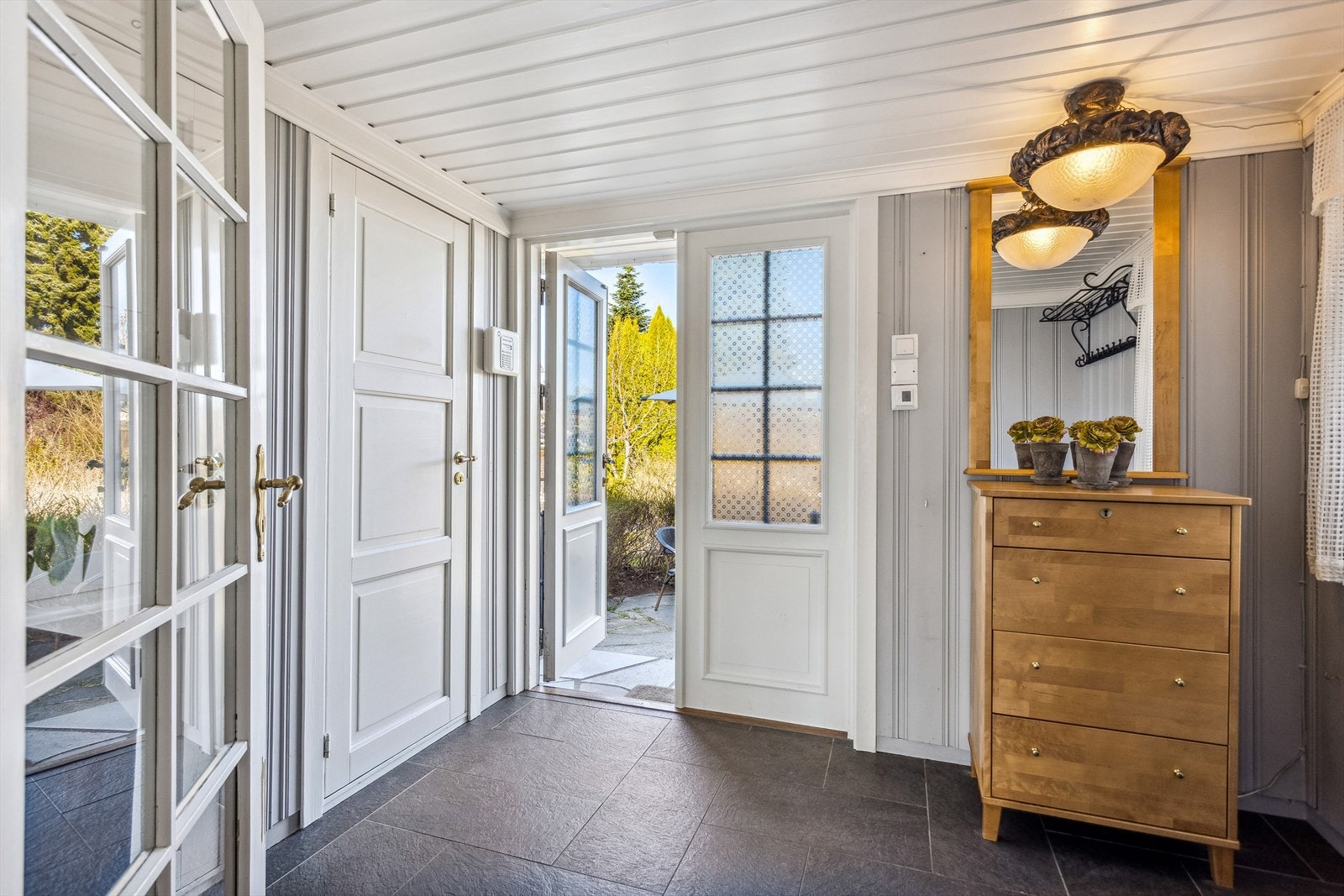 Via boligens hyggelig inngangsparti med hellelagt uteplass og trapp med smijernrekkverk, ønskes du velkommen inn! Galleribilde