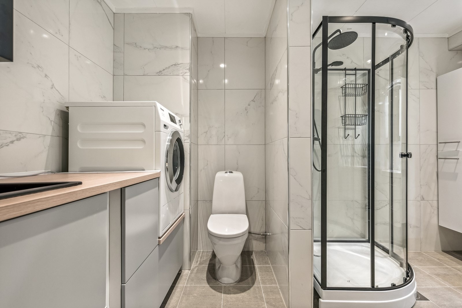 Badet er utstyrt med dusjkabinett fra 2023, gulvstående wc og stor servantinnredning med skuffer og sideskap. Galleribilde