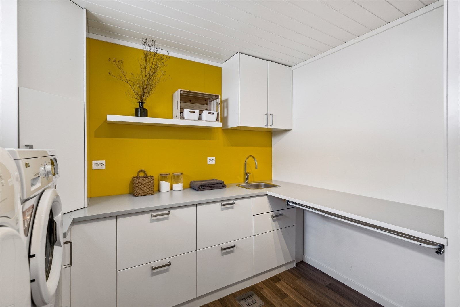 Boligen innhar et stort vaskerom på hele 9 m² med innredning som strekker seg over hele tre vegger. Galleribilde