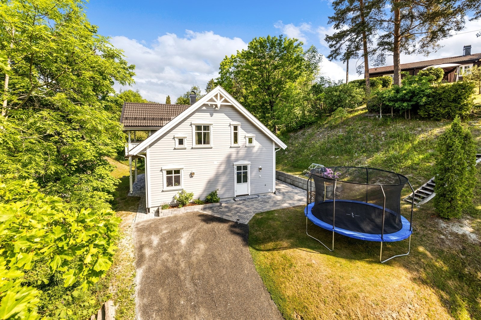 Her er det plass til trampoline . Steinbelagt foran huset, fine kantsteiner rundt huset. Galleribilde