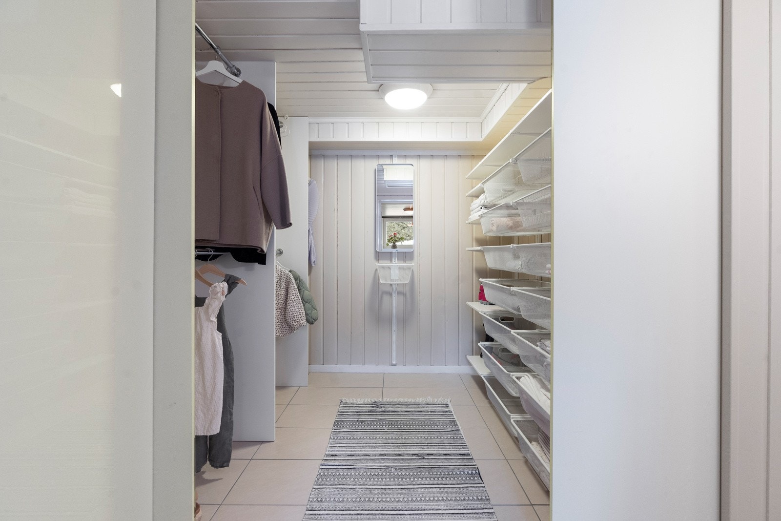 Walk-in garderoben er smakfullt utført og byr på god plass til oppbevaring av diverse klær og tilbehør. Galleribilde