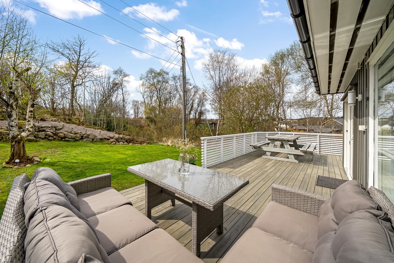 Stor solrik terrasse med adkomst fra kjøkkenet og videre adkomst til hagen. Galleribilde