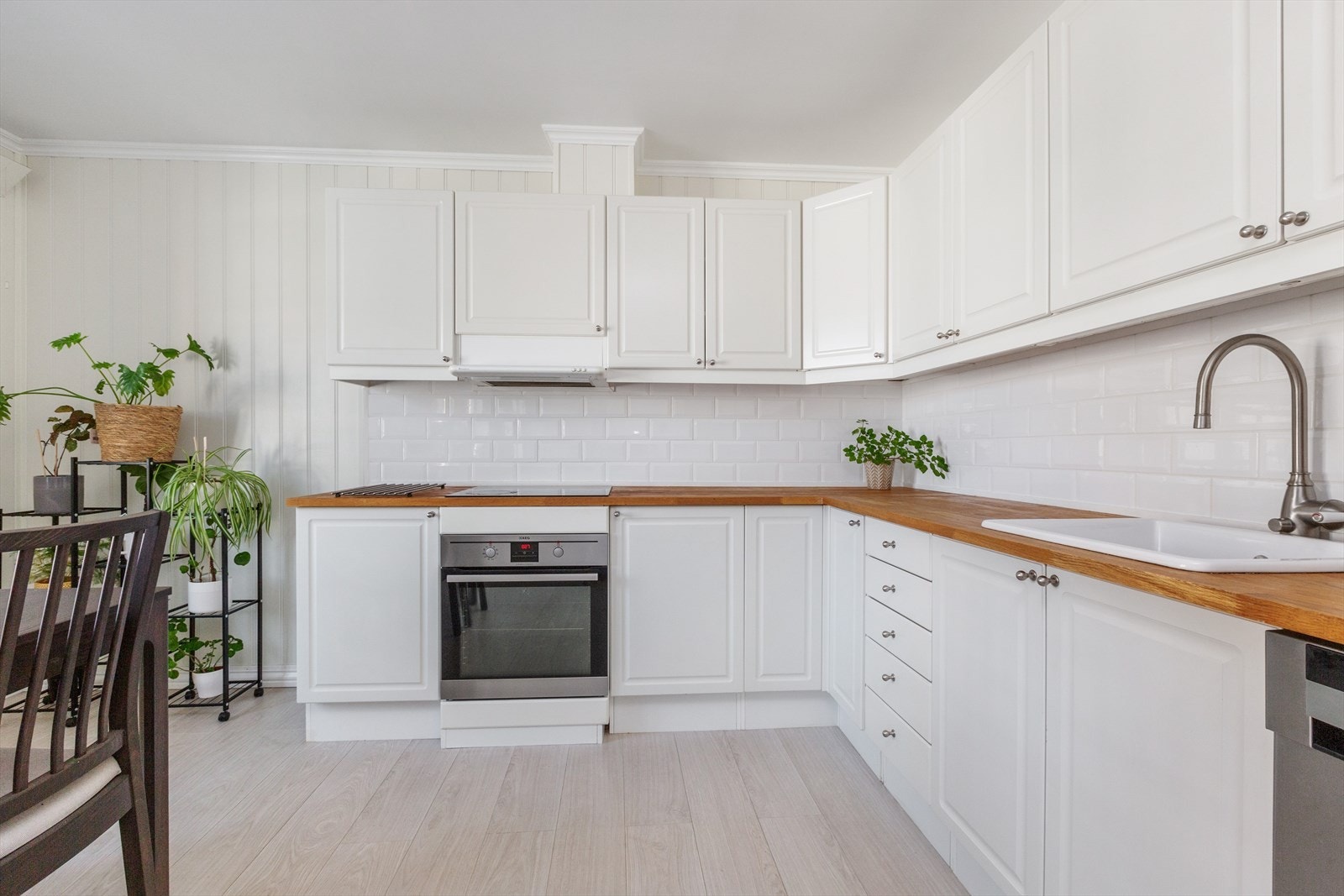 Pen kjøkkeninnredning med lyse, profilerte fronter og benkeplate i heltre Galleribilde