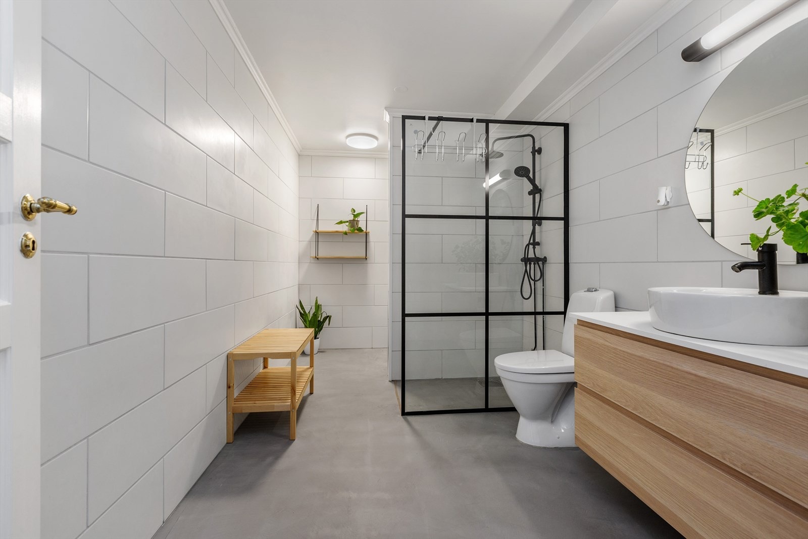 Badet er innredet med dusjvegg, WC og servant med tilhørende skap Galleribilde