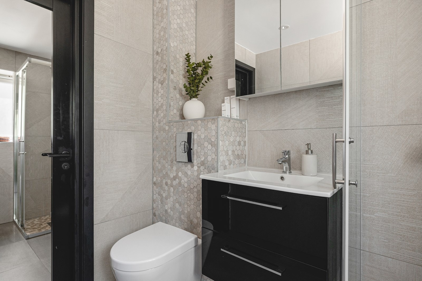 Badet har tidsriktige farge- og materialvalg, behagelig gulvvarme og downlights i himling Galleribilde