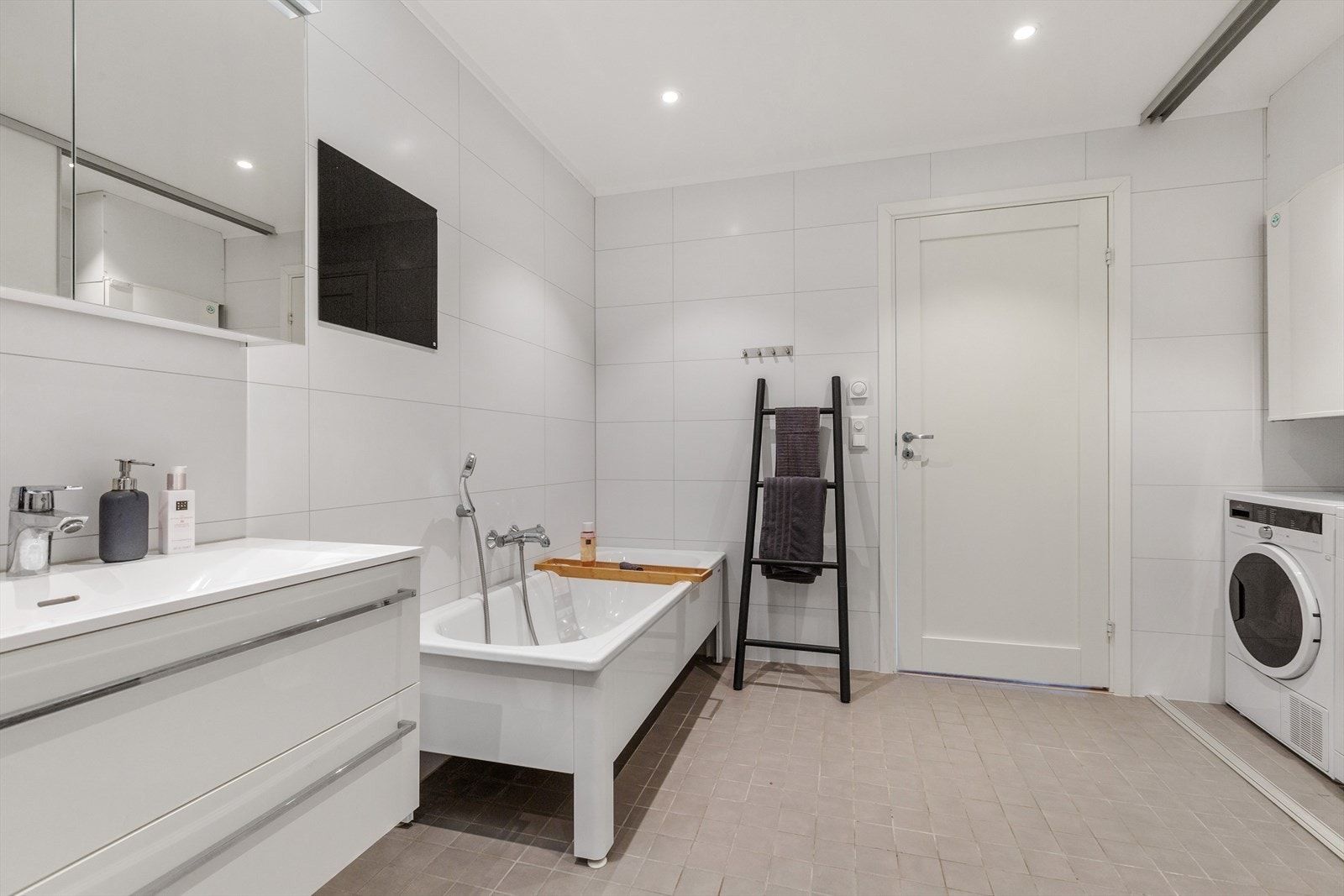 Vaskemaskin, varmtvannsbereder og annet teknisk er plassert på en egen del av badet som praktisk kan avstenges med skyvedører Galleribilde