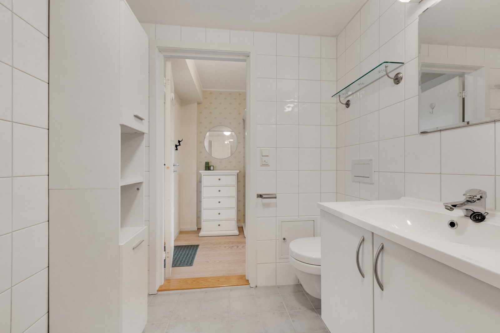 Badet inneholder dusjhjørne med skyvedører i glass, vegghengt wc, servantskap med ett-greps blandebatteri, speil på vegg,belysning og opplegg for vaskemaskin. Nye dusjdører fra 2020. Nytt toalett ca 2018 Galleribilde