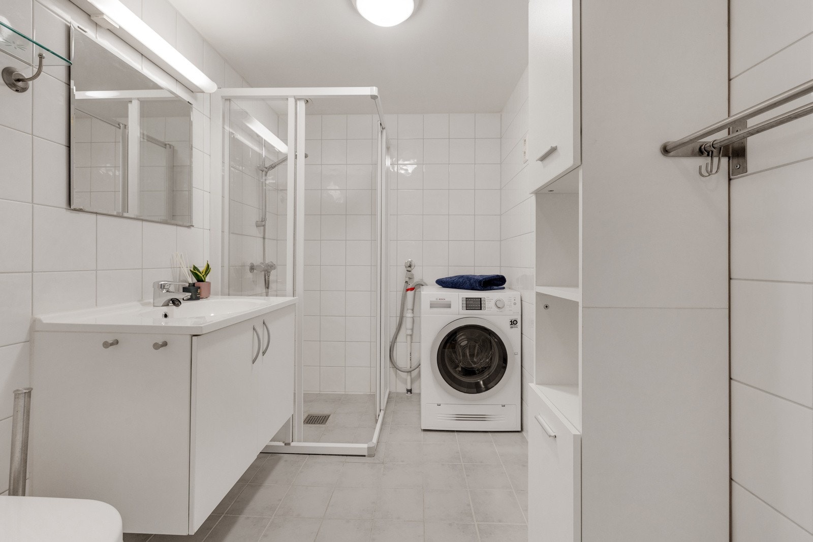 Lekkert flislagt baderom med varmekabler i gulv og opplegg for vaskemaskin.Flislagt baderom fra byggeår med gulvvarme. Galleribilde