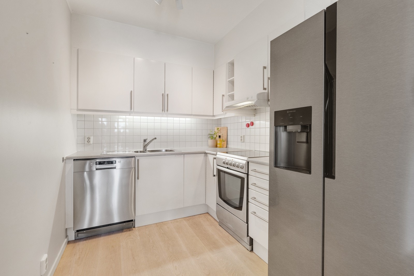 Fliser over benk. Utstyrt med hvitevarer som komfyr med platetopp, oppvaskmaskin, frittstående kjøl/ fryseskap samt ventilator over kokesone. Delvis åpen løsning til stue. Galleribilde