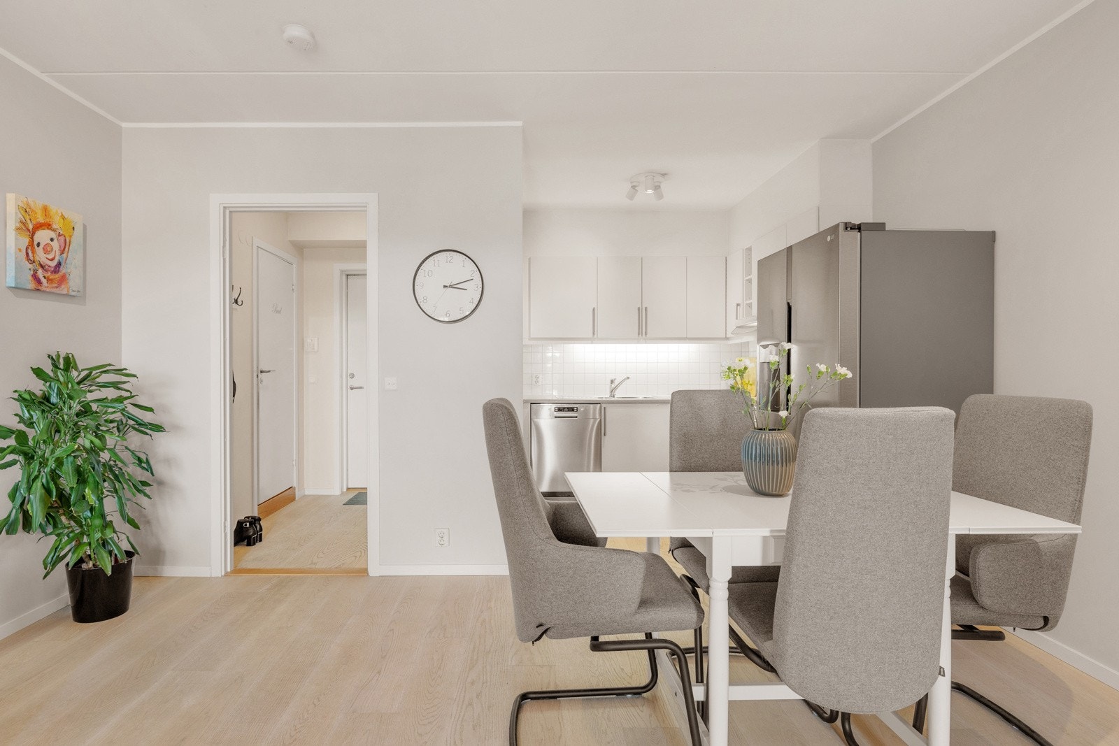 Lyst og stilrent kjøkken med god benk- og skapplass. Kjøkkeninnredning fra Sigdal med hvite glatte fronter, benkeplate i laminat med nedfelt kum og ett-greps blandebatteri. Galleribilde