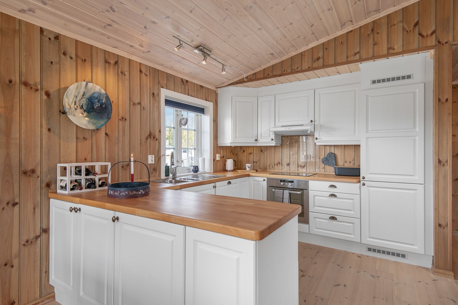 Delikat kjøkkeninnredning med god oppbevaringsplass i under- og overskap Galleribilde