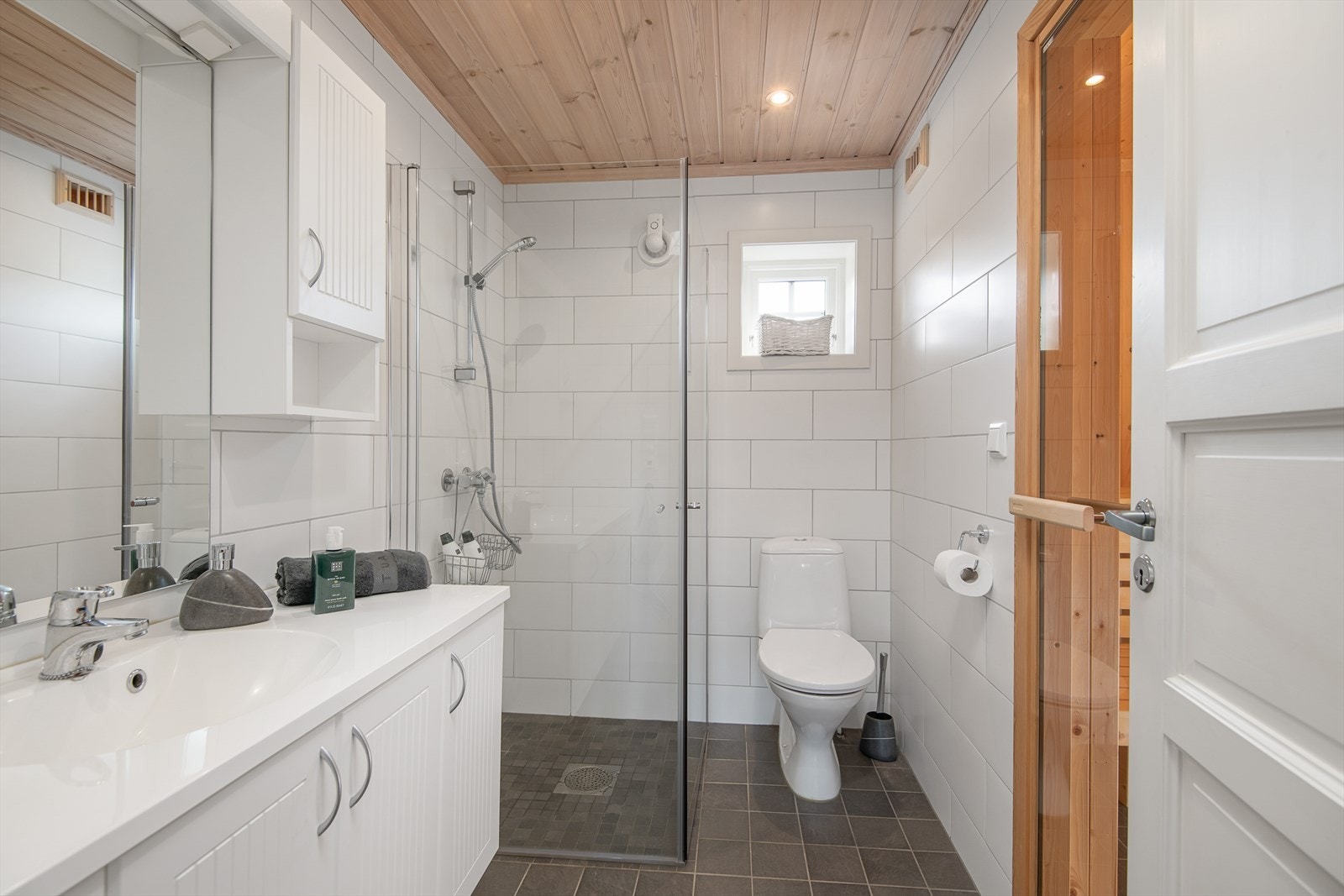 Lyst og flislagt baderom med gulvvarme Galleribilde