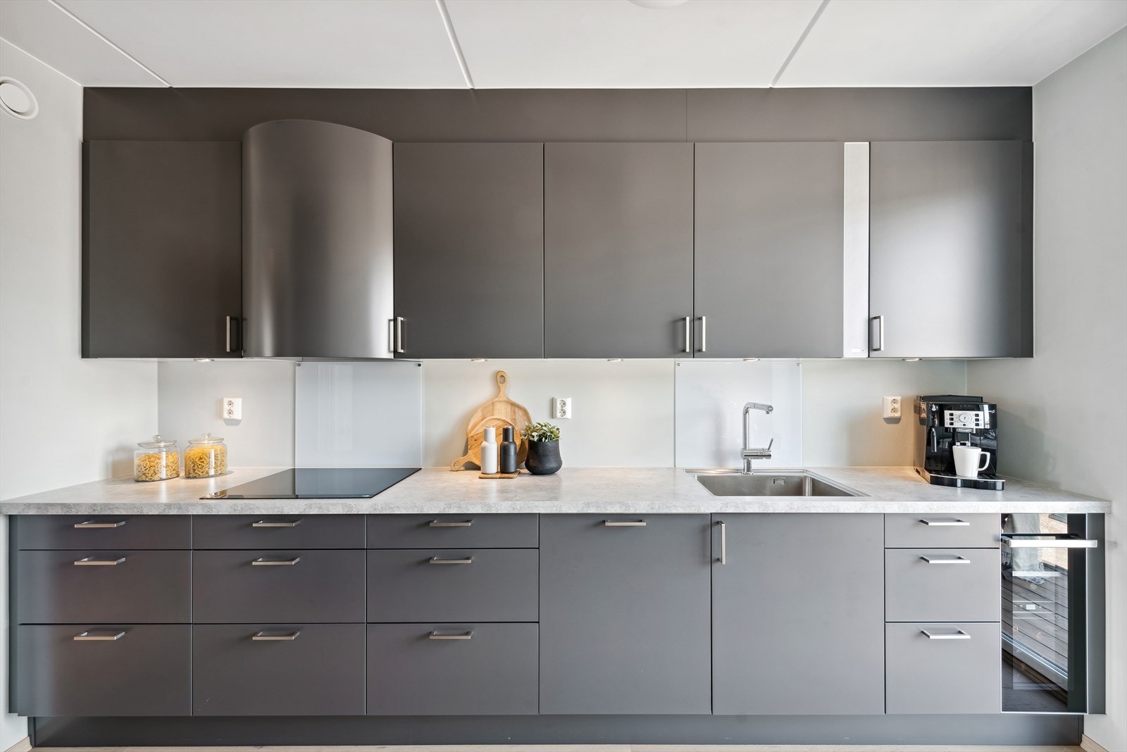 Innredningen har matte fronter, benkeplater i laminat, plater i glass over benkeskap, underlimt oppvaskkum, ventilator og integrerte hvitevarer. Galleribilde