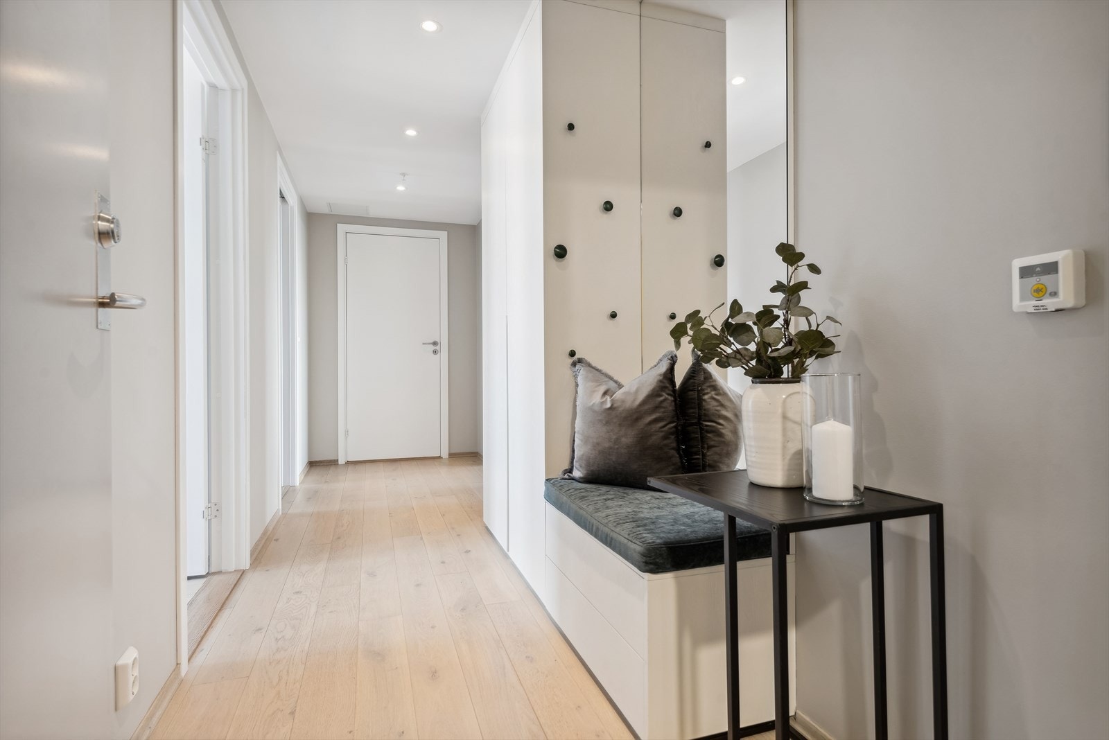 Du ønskes velkommen inn i en lys og innbydende entré med downlights i himling. Det er god plass til å henge fra seg yttertøy og sko i spesialtilpasset og plassbygget garderobeskap. Praktisk sittebenk med oppbevaring. Galleribilde
