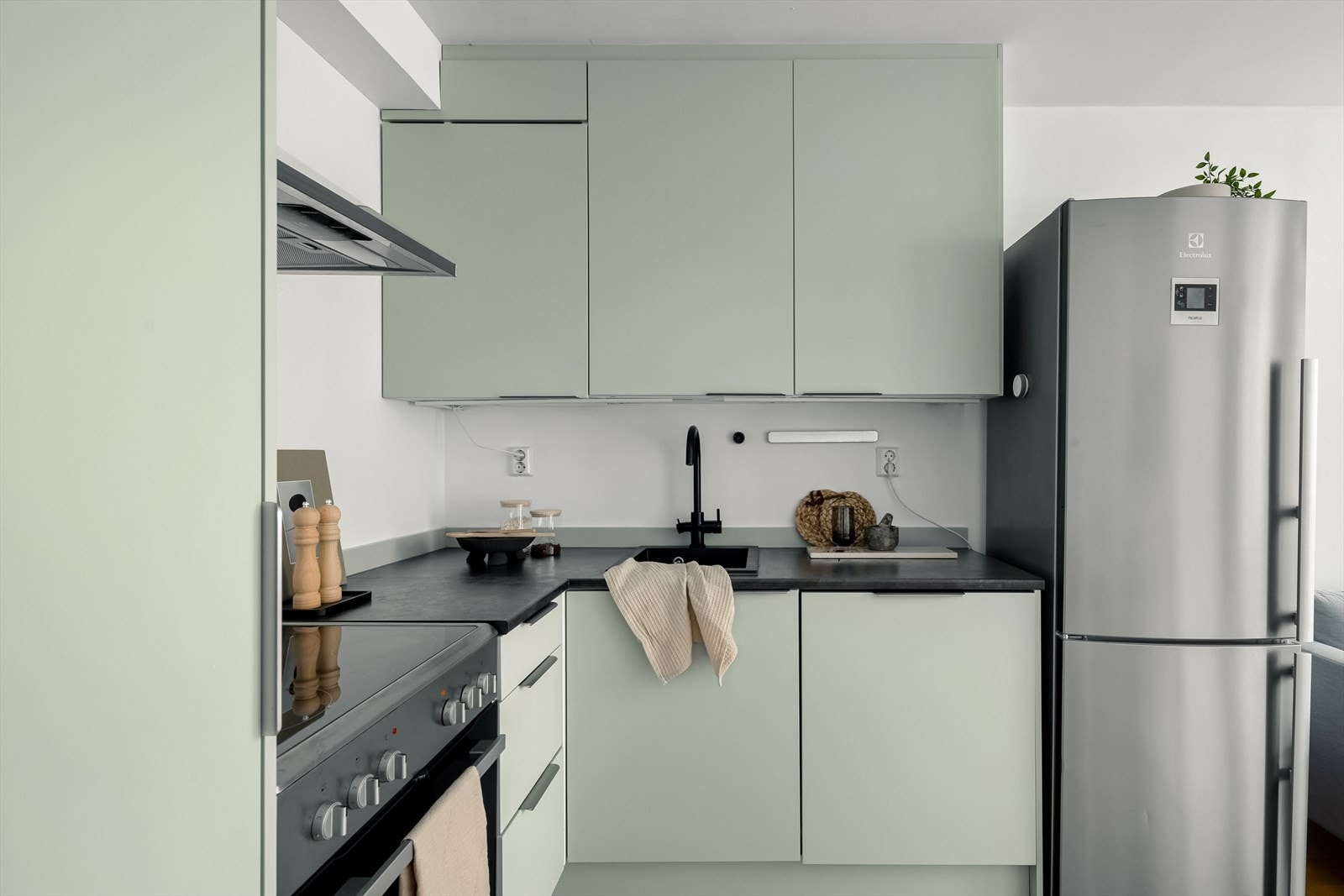 Kjøkkenet har slette fronter i en lekker grønnfarge, benkeplate i mørk laminat, store overskap som gir godt med oppbevaringsplass, integrert oppvaskmaskin og opplegg/plass til kjøleskap. Galleribilde