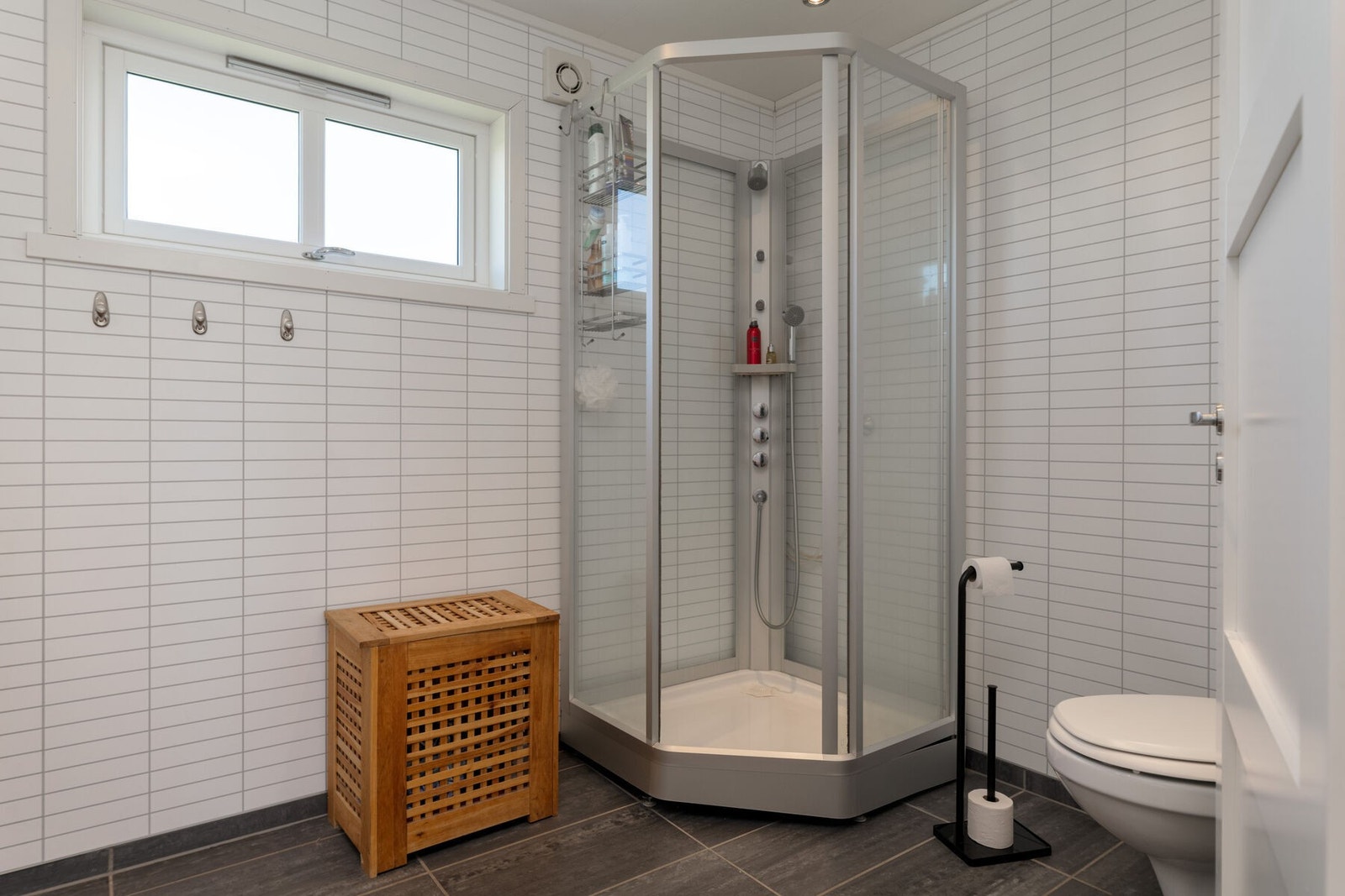 Badet er innredet med servantmøbler, vegghengt toalett og dusjkabinett Galleribilde