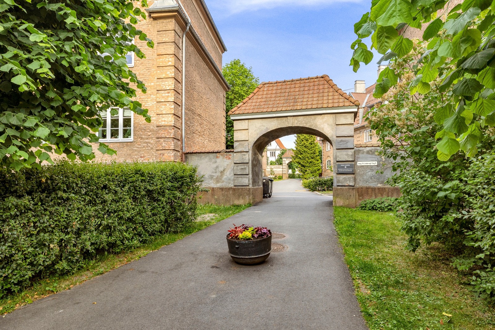 Bakgården er parkmessig opparbeidet med plenareal, trær, beplantninger, velstelte bed og asfalterte arealer. Galleribilde
