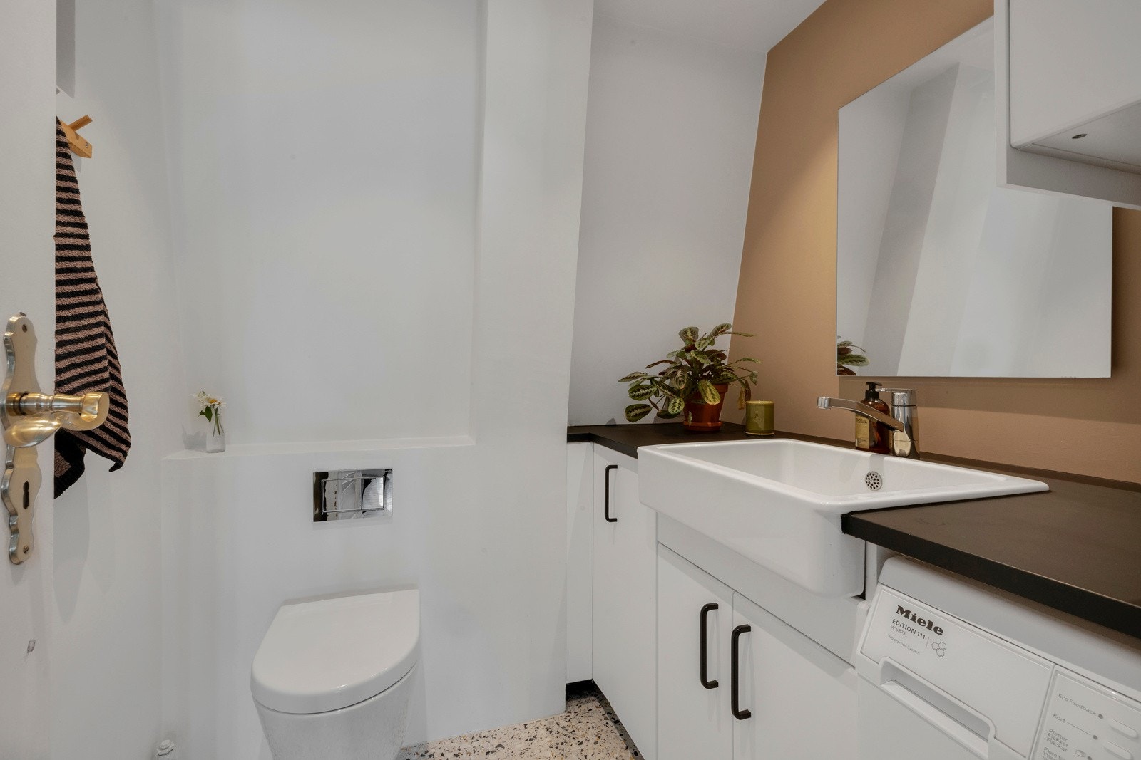 Toalettet er vegghengt og under benken er det opplegg for vaskemaskin. Galleribilde