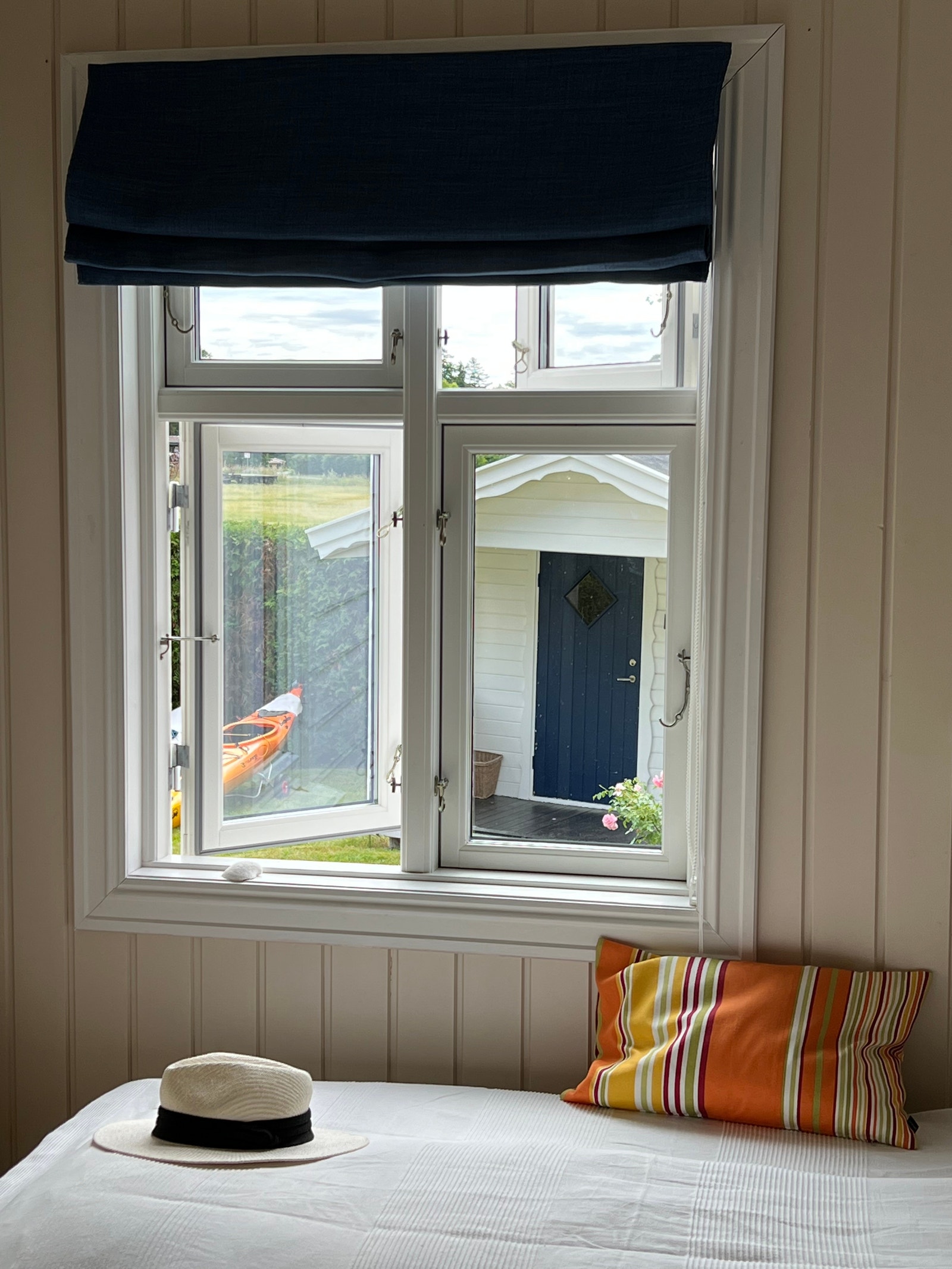 Utsikt til annekset i hagen med høy hekk (tomten grenser til jordbruksområde.). Galleribilde