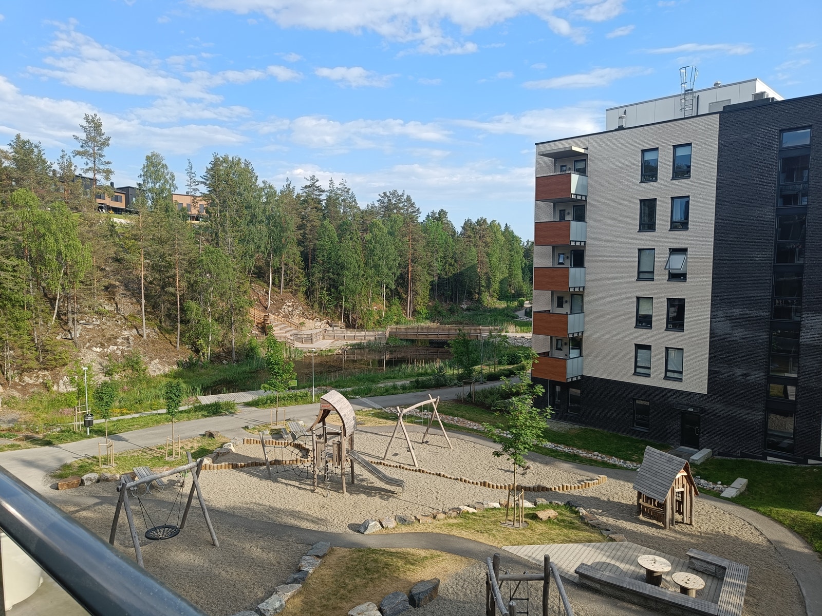 Fin utsikt fra terrasse mot lekeplass og Salamanderdammen Galleribilde