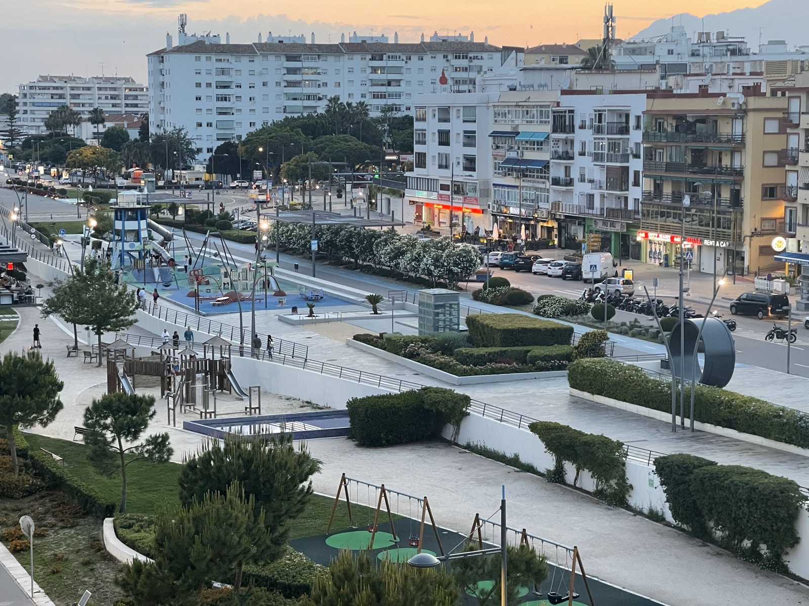 Utsikt fra terrasse mot by og lekeplassområde Galleribilde