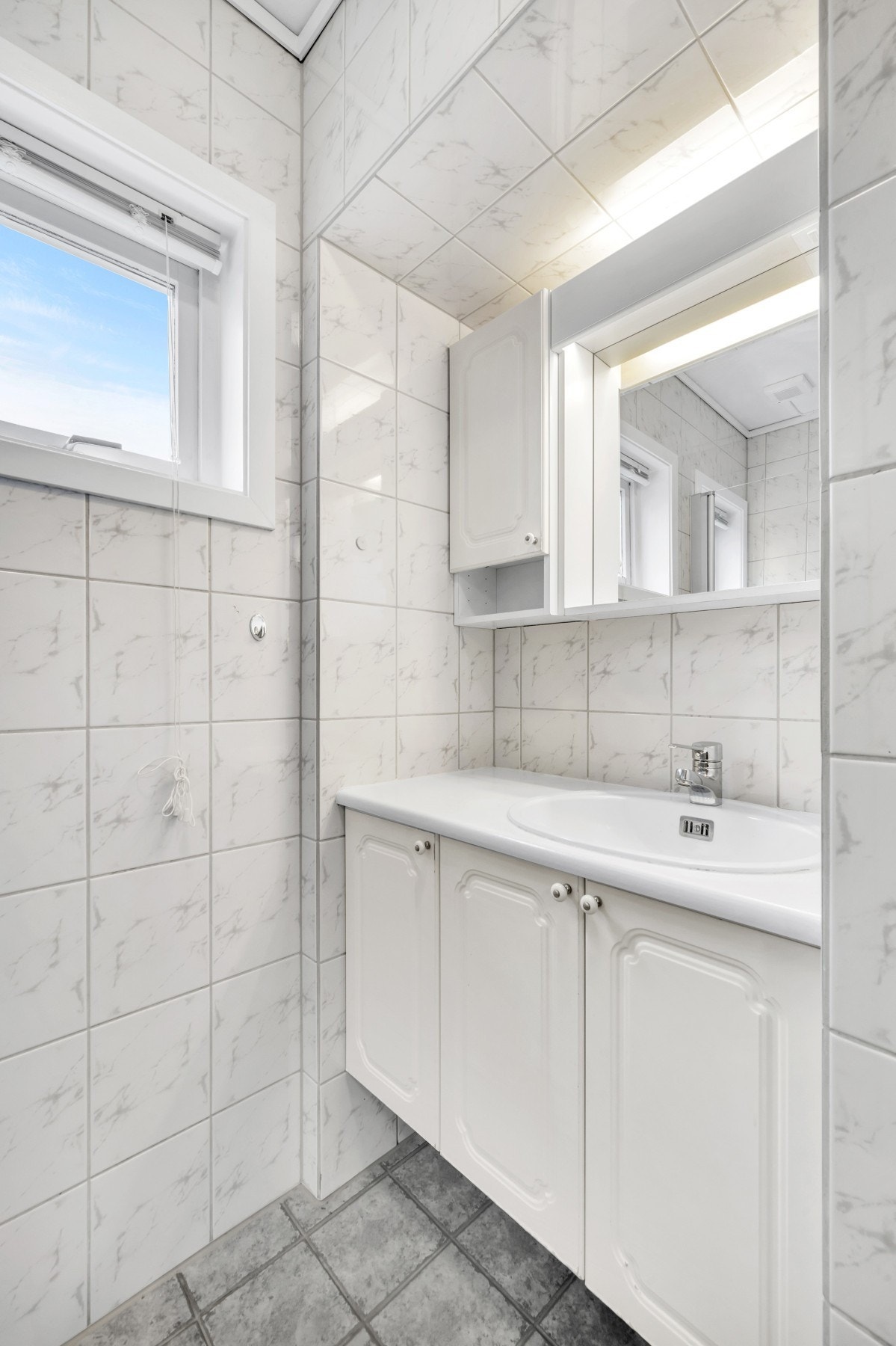 Lyst bad med lagring i servantskap. Vindu gir god luftingsmuligheter Galleribilde