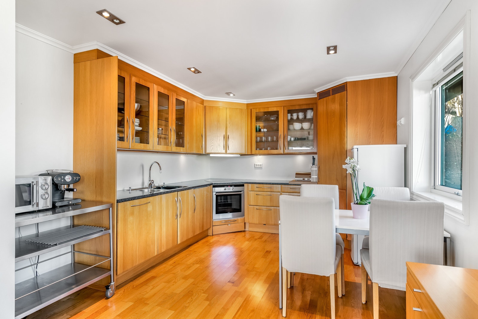 Kitchen w/integrated appliances and corner fridge
Stone worktop Galleribilde