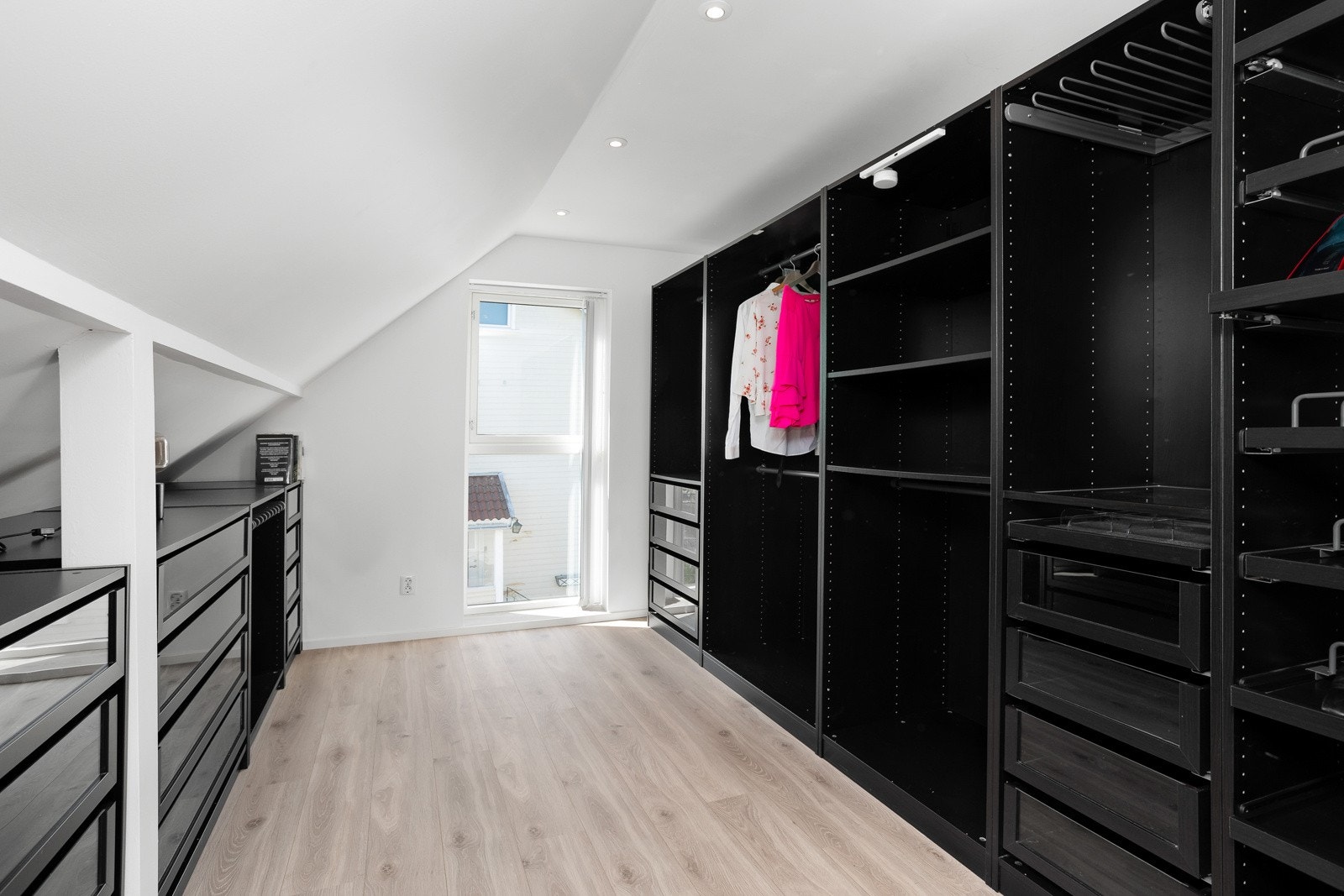 Garderoberommet var tidligere hjemmets fjerde soverom, men ble om bygget i 2020 til dagens løsning. med massevis av klesoppbevaringsplass på begge sider av rommet med skuffer, hyller og hengeanordninger. Galleribilde