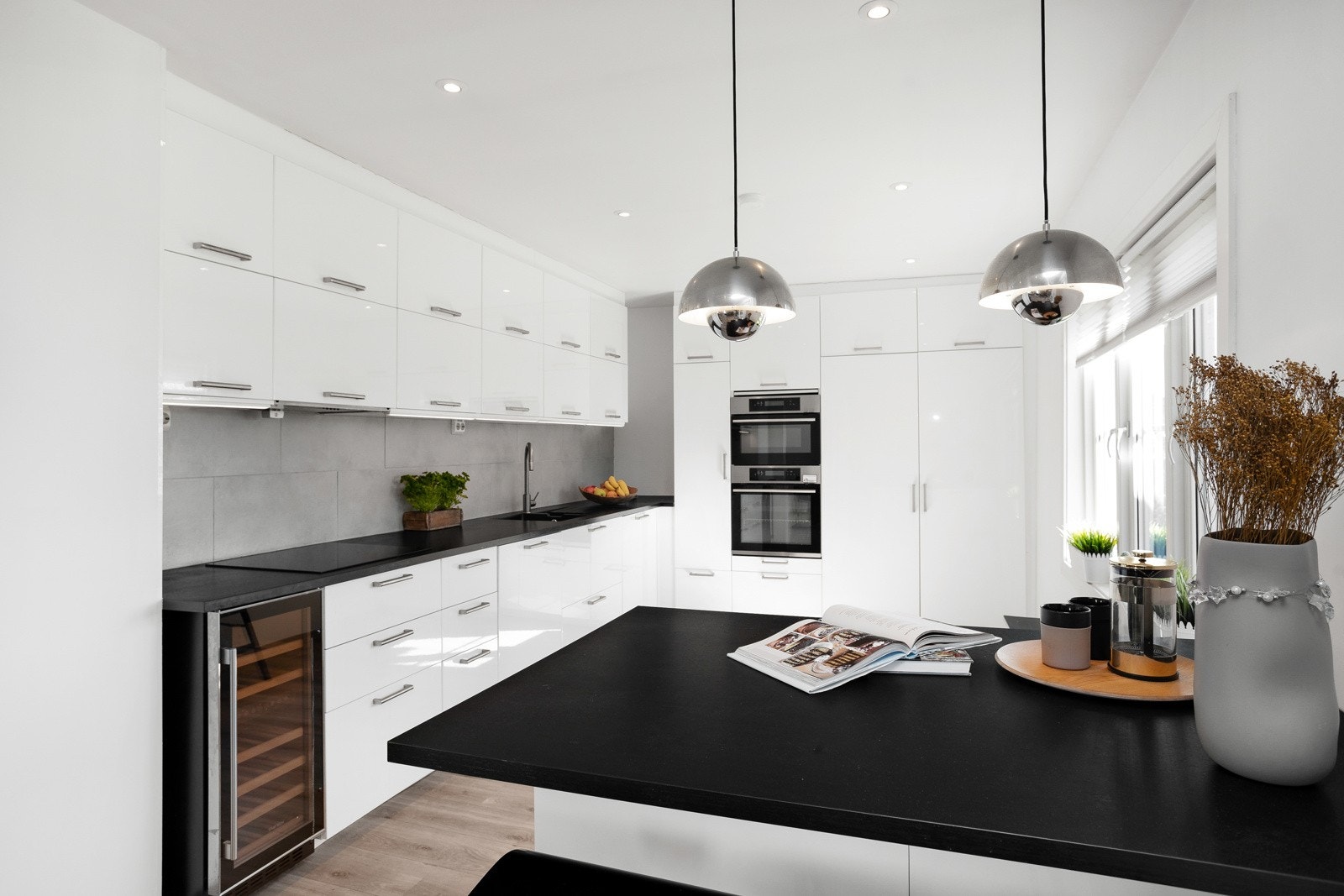 Med åpen løsning fra spisestuen, blir kjøkkeninnredningen som et "møbel" i rommet hvor det bys på godt med skap-/benkeplass og innredning med pent tilpassede og stramme designfronter. Galleribilde