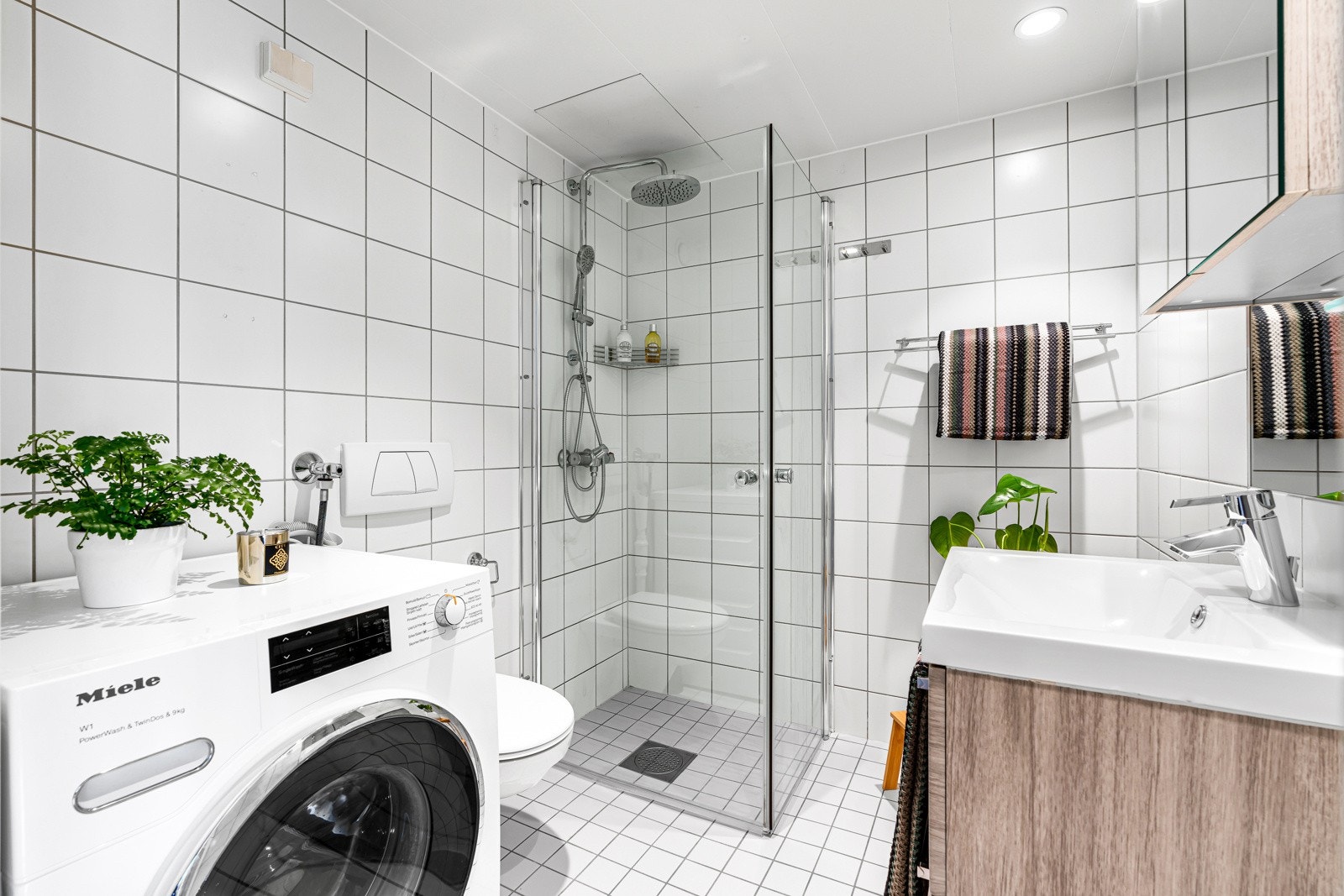Badet er tidløst hvitt og helfliset, og er en prefabrikkert våtromskabin fra byggeår. Galleribilde