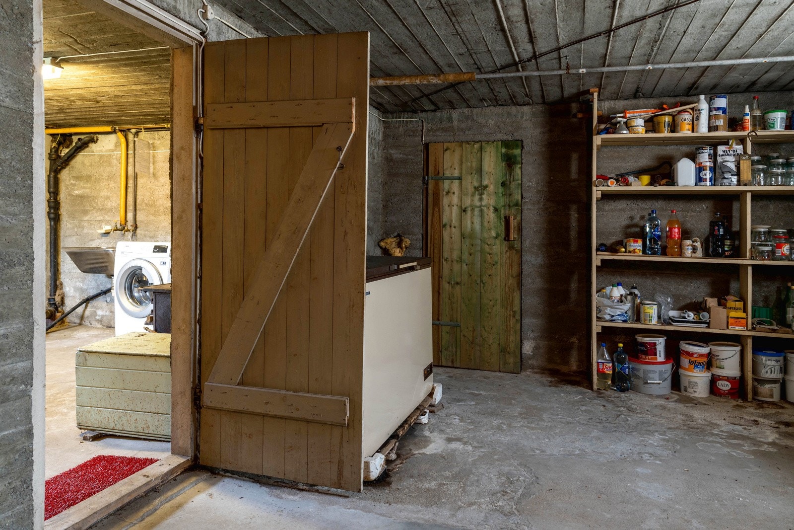 Kjelleren har i likhet med loftet tilgang fra entreen. I kjelleren er det montert enkle labankdører av tre mellom rommene. Galleribilde