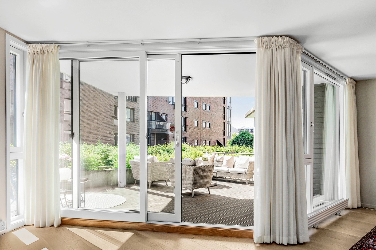 Romslig, lys og trivelig stue med direkte utgang til en stor, privat terrasse med plass for utemøblement, solsenger og grill. Galleribilde