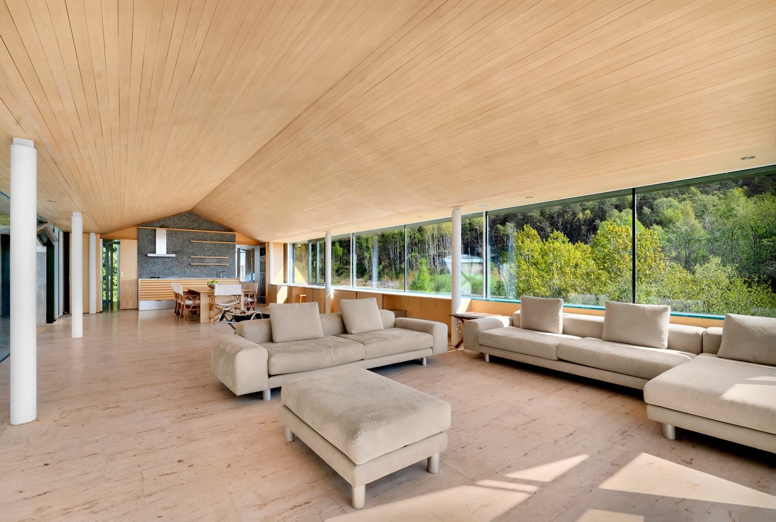 Gulvet, både inne i stuen og ute på terrassen, er belagt med store kalksteinfliser som gir en sammenhengende flate uten terskler. Galleribilde