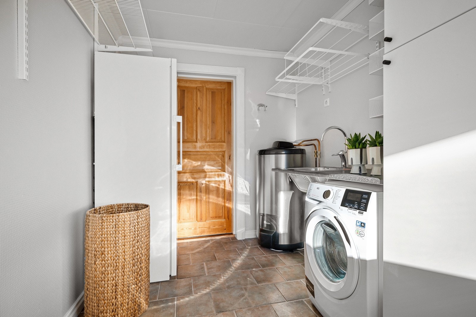 Vaskerommet er innredet med skapinnredning med slette, lyse fronter samt laminert arbeidsbenk med nedfelt vaskekum. Galleribilde