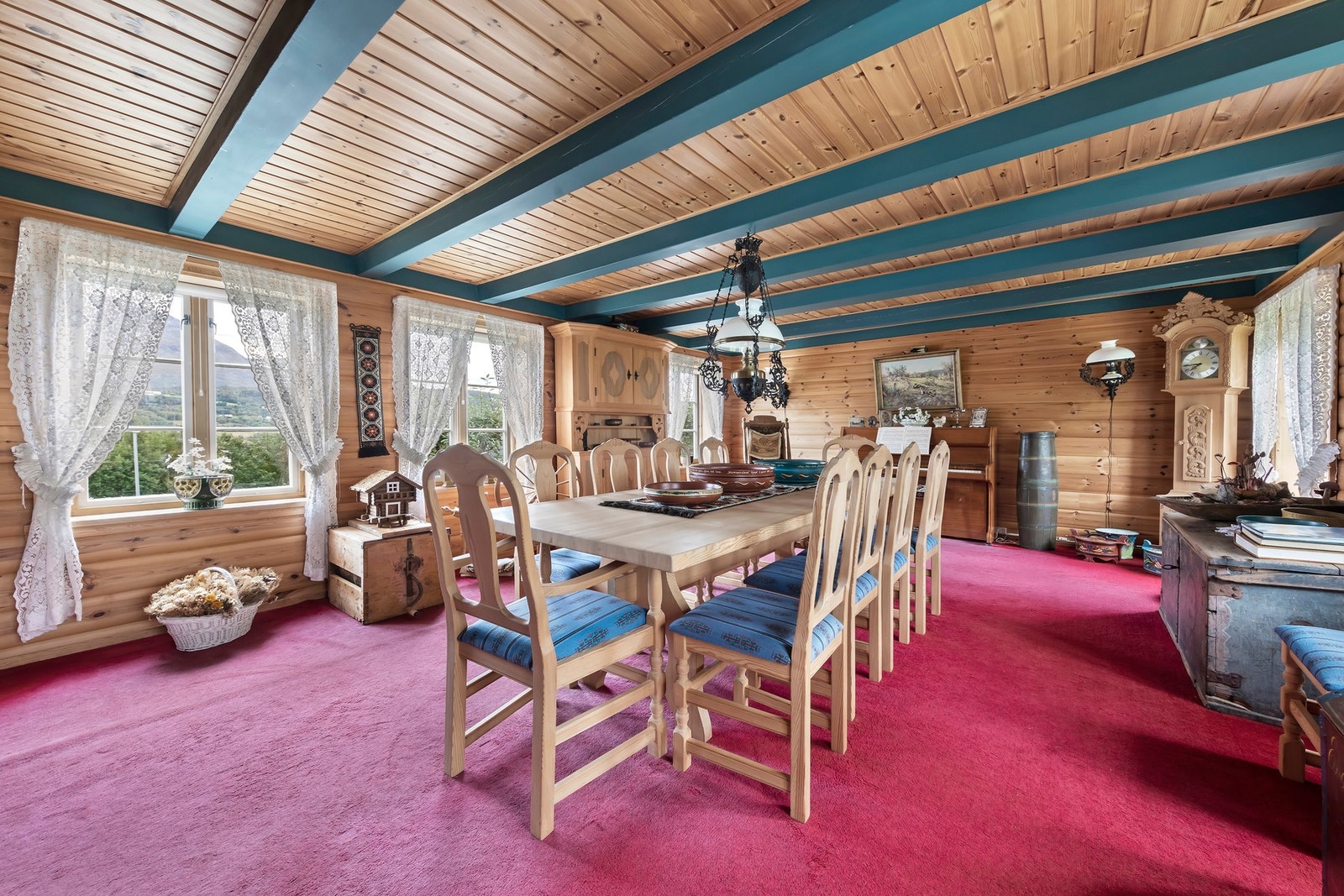 Stuen har teppe på gulvet, tømmervegger og panel i taket Galleribilde