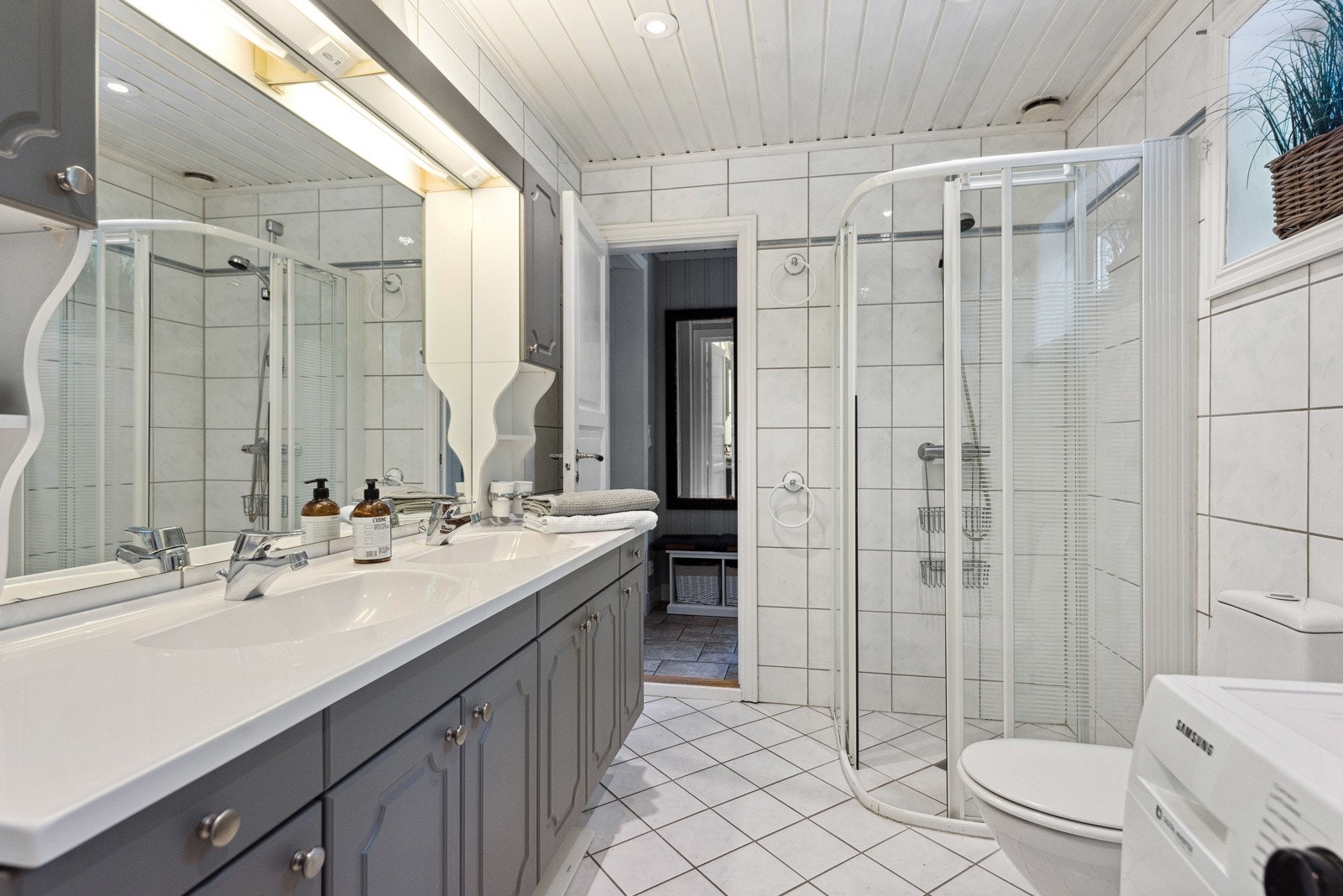 Boligen har ett romslig bad med flislagte overflater Galleribilde