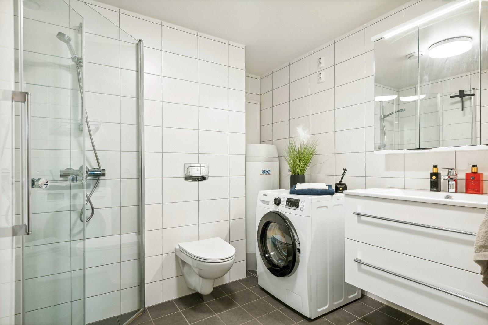 Videre er badet utstyrt med dusjhjørne og vegghengt toalett. Galleribilde