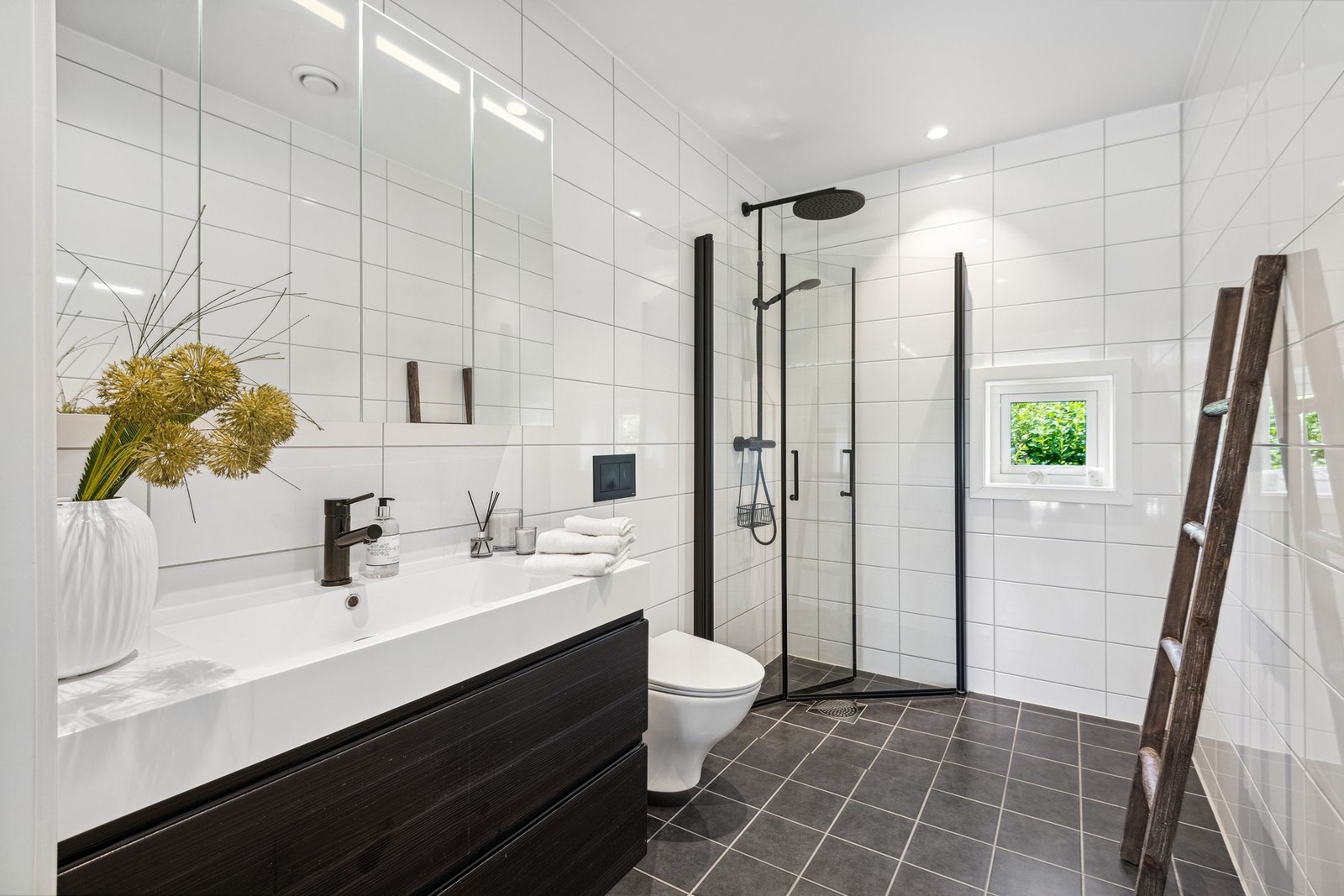 Pent flislagt bad med smakfull innredning og dusjarmatur. Galleribilde