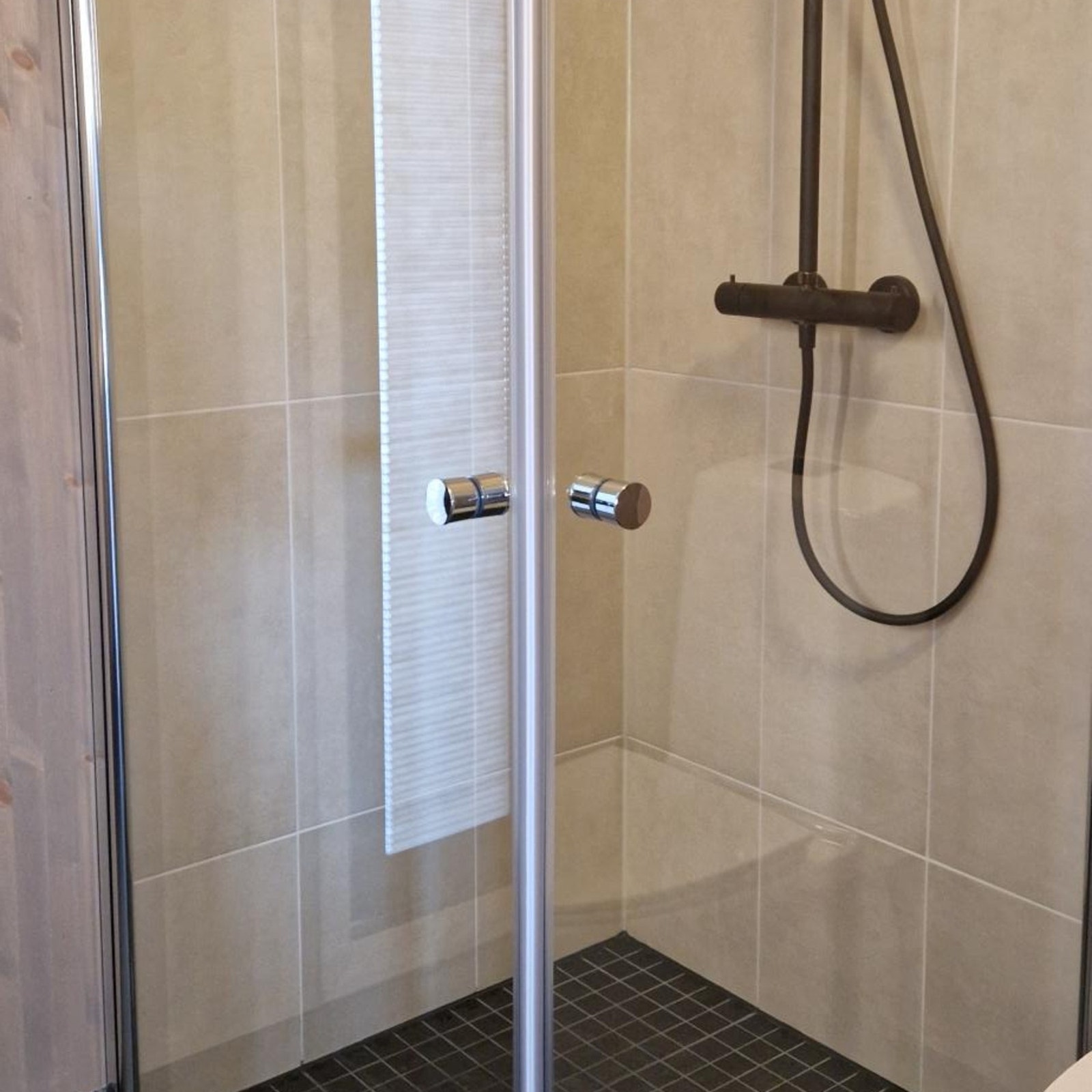 Bad 1 er oppgradert med LB ekstra fliser i dusjnisje og Tapwell takdusjpakke i matt sort Galleribilde