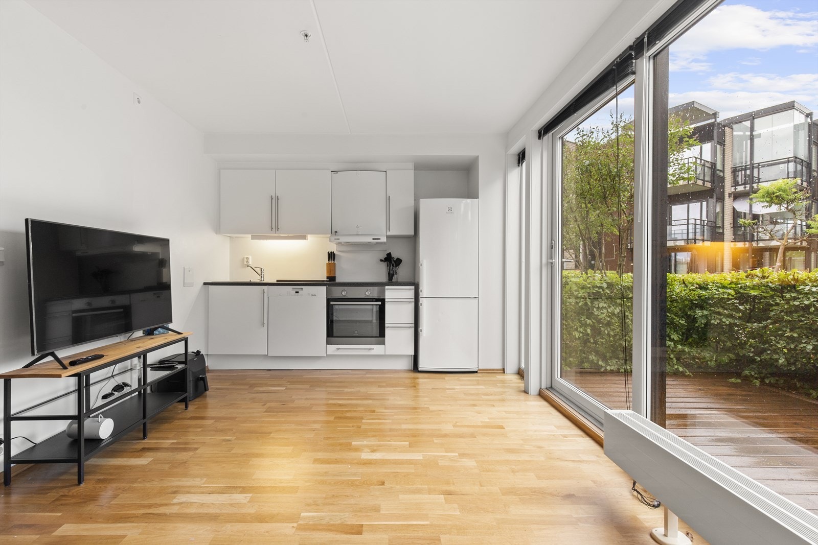 Kjøkken med integrert komfyr og platetopp. Frittstående kjøleskap. Galleribilde