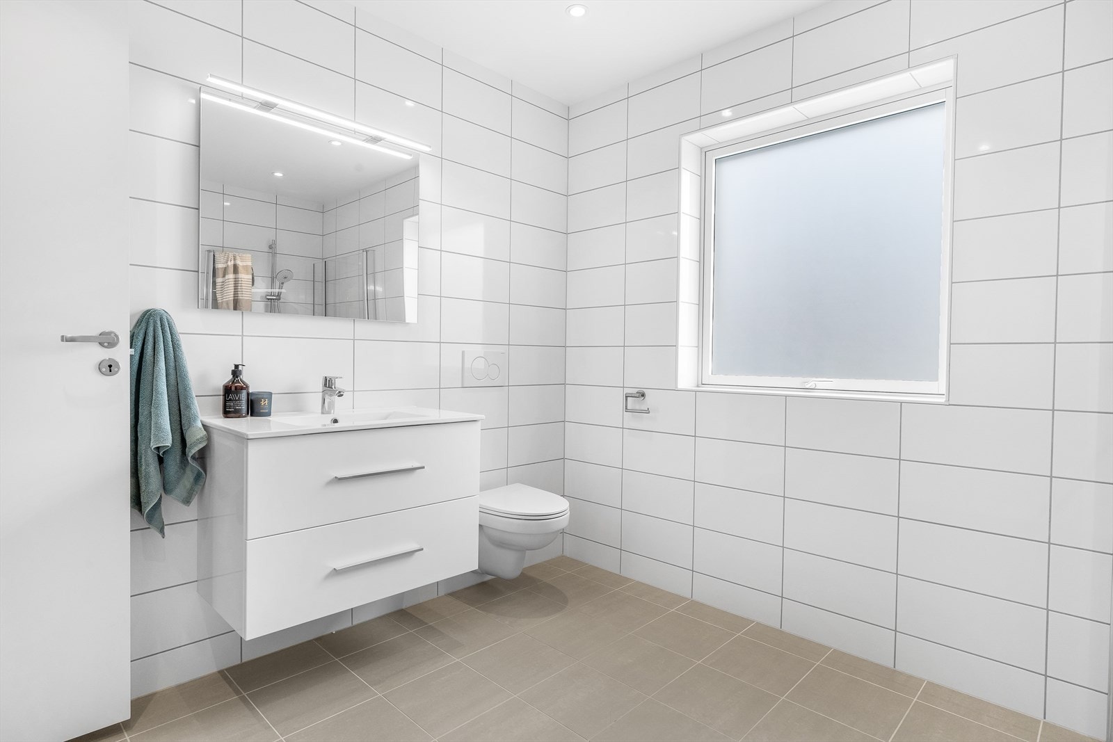 Begge badene er flislagt i samme fargetoner, som skaper en god helhet Galleribilde